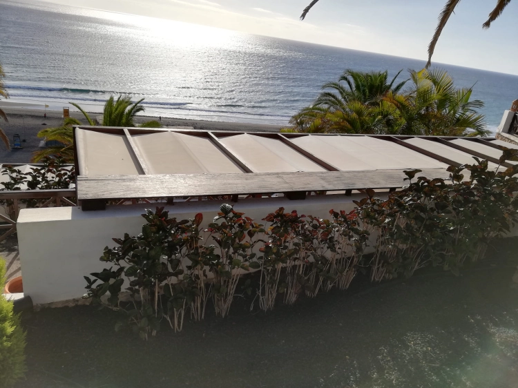 Bande de pare-soleil romaine économique 2,1x7 m montée sur une terrasse avec vue sur la mer