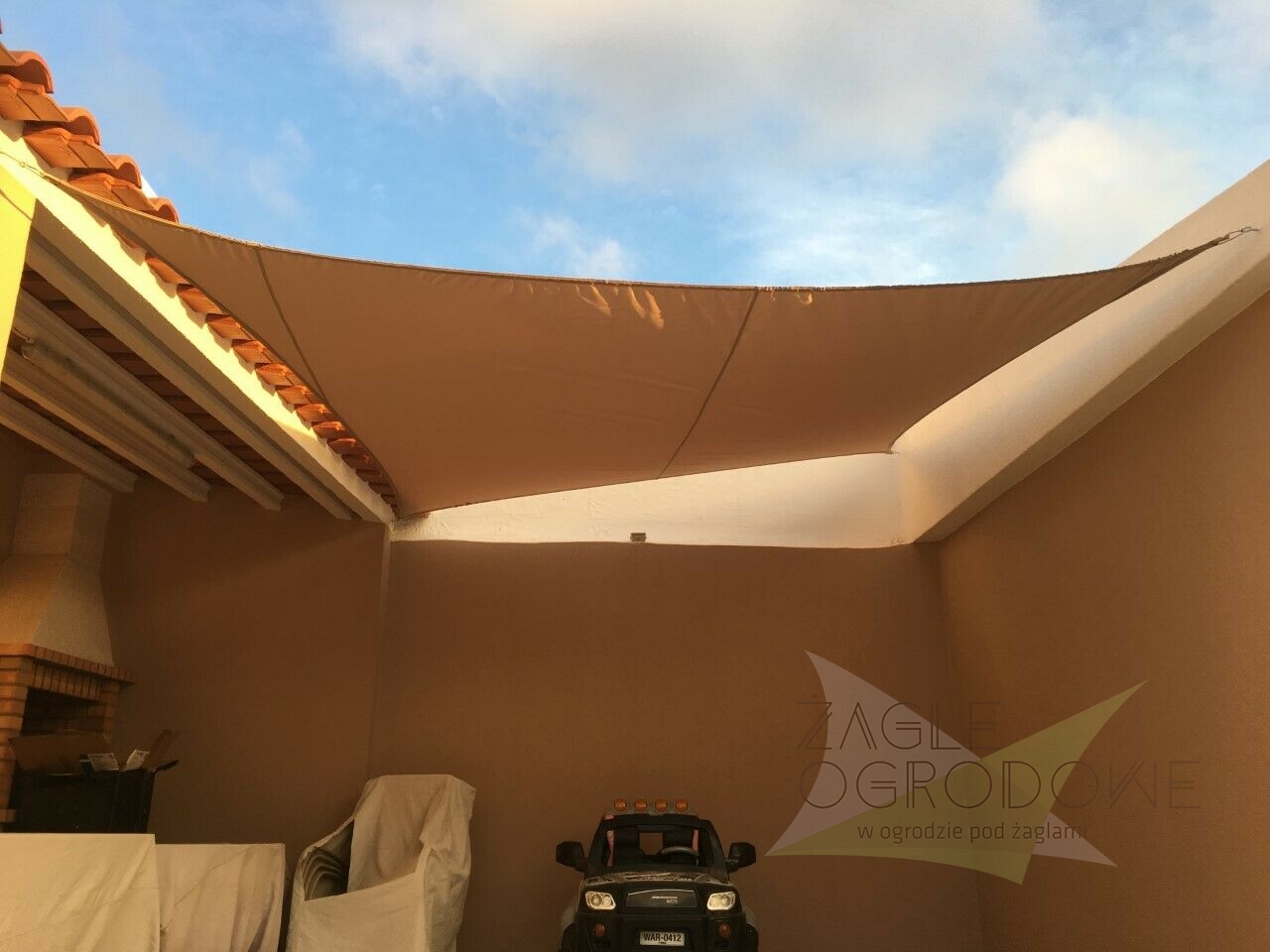 Vela ombreggiante rettangolare impermeabile premium 4,2x4,7 m istallata come copertura per terrazza in colore beige