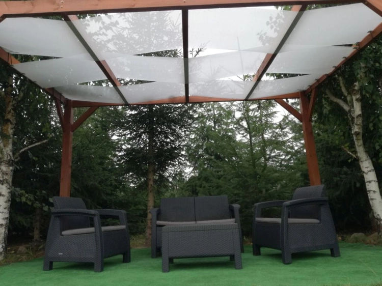Voile d'ombrage de pavillon blanc monté sur une pergola en bois au-dessus d'un salon de jardin