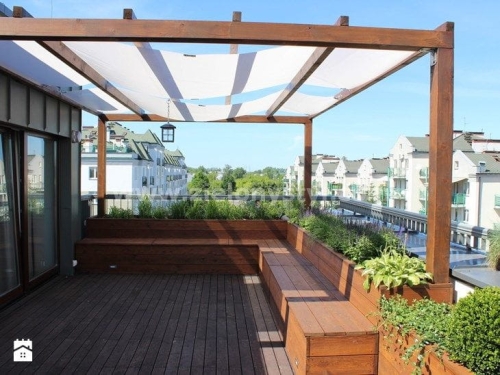 Voile de protection solaire blanche 1x5 m installée sur une pergola de terrasse en bois sur le toit d'un bâtiment