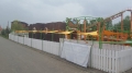 Toldo vela de jardín triangular amarillo instalado sobre barandillas en un parque de atracciones para protección solar