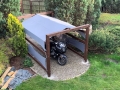 Toldo vela impermeable 3x3 m montado sobre una estructura de madera encima de una moto