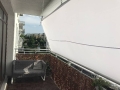 Vela de sombra cuadrada blanca 3x3 m instalada en el balcón como protección solar Premium