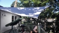 Voile d'ombrage carrée blanche 3x3 m installée sur une terrasse, offrant ombre et protection contre la pluie