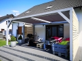 Voile d'ombrage imperméable 3x3 m montée sur une pergola de terrasse en bois avec des meubles en palettes