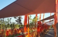 Vela de sombra cuadrada roja Premium 4x4 m instalada sobre la terraza para dar sombra y protección solar