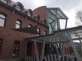 Voile d'ombrage triangulaire imperméable Premium montée sur la façade en briques d'un restaurant