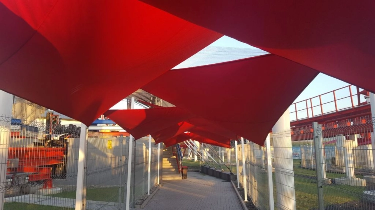 Toldo vela triangular rojo 5x5x7 m Premium sobre un paso de peatones
