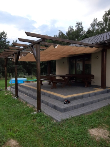 Vodotesná výsuvná záhradná plachta Premium 1,5x5 m namontovaná na drevenej pergole nad terasou