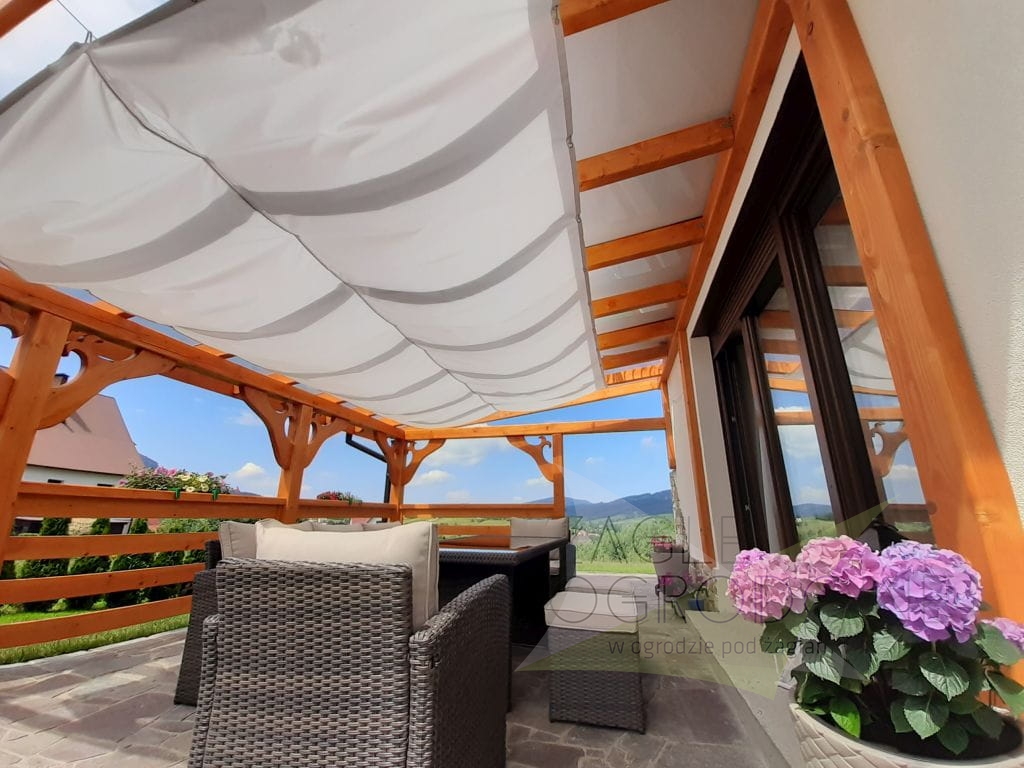 Voile d'ombrage rétractable blanche sur terrasse avec pergola en bois et kit de montage par câbles