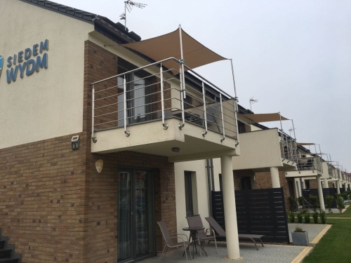 Wasserdichtes Sonnensegel nach Maß installiert über einer modernen Terrasse und einem Balkon