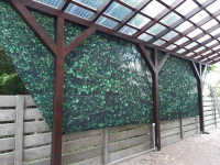 Rideau de jardin robuste avec imprimé de feuilles vertes, installé sur mesure sous un toit de terrasse