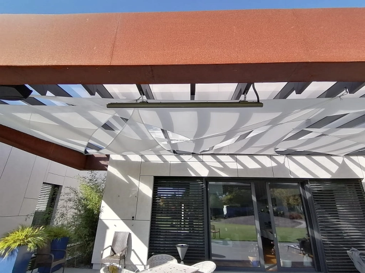 Vela de sombra triangular blanca instalada sobre la terraza de una casa moderna