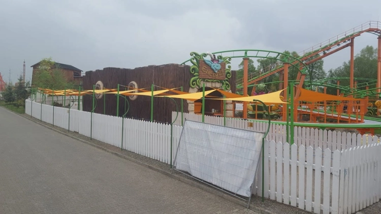 Conjunto de velas de sombra triangulares amarillas premium que sombrean un camino en un parque de atracciones