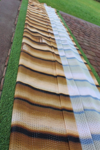 Rideau de jardin avec impression imitation planches de bois, étalé sur l'herbe à côté d'une allée