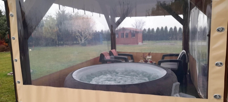 Przezroczysta plandeka na taras osłaniająca altanę z jacuzzi i meblami wypoczynkowymi w ogrodzie turn-lock