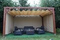 Tenda a pacchetto parasole beige in HDPE montata su pergola in legno con set di mobili da giardino