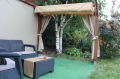 Tenda a pacchetto per terrazza in HDPE beige su misura montata su una pergola in legno in giardino con mobili in polyrattan