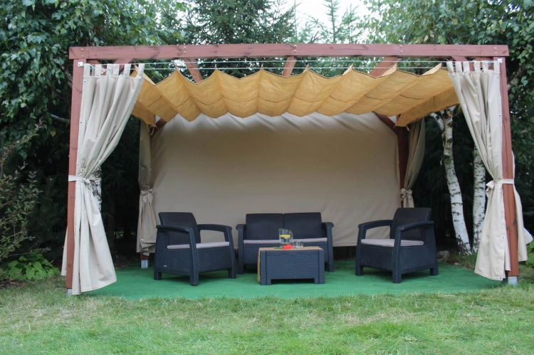 Tenda a pacchetto parasole in HDPE beige su misura montata su una pergola in legno per terrazza con set di mobili da giardino