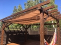 Vela da giardino avvolgibile Premium impermeabile su pergola marrone con amaca e assi da terrazza