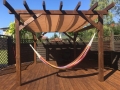 Vela ombreggiante beige impermeabile estensibile 2,5x3 m montata su pergola in legno con amaca sulla terrazza