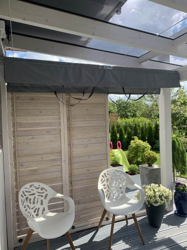 Store horizontal gris sur mesure installé sous le toit en verre d'une terrasse dans une véranda