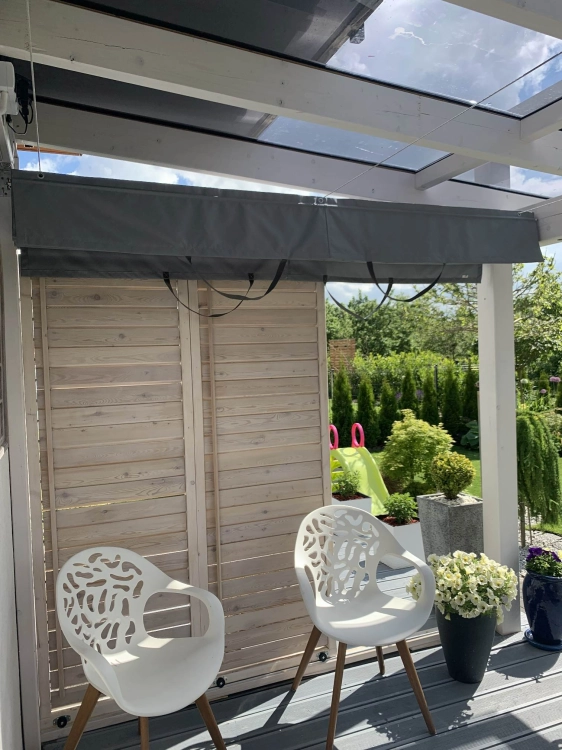 Store horizontal gris sur mesure installé sous le toit en verre d'une terrasse dans une véranda