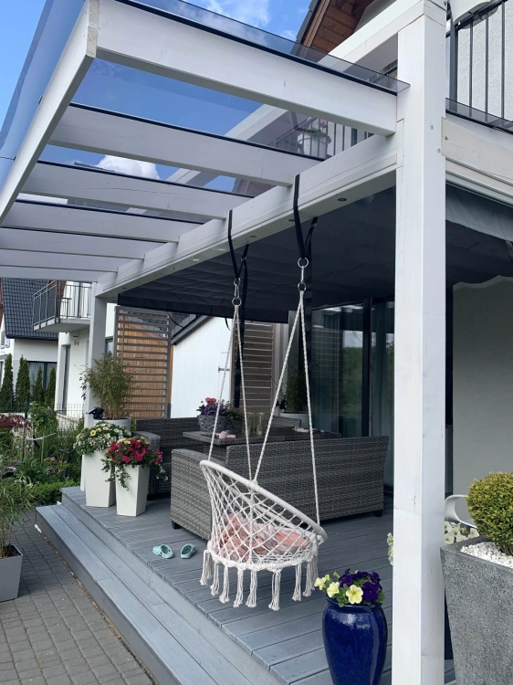 Store horizontal solaire gris sous un toit de terrasse en verre avec mobilier de jardin moderne