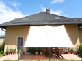 Tenda a vela bianca impermeabile 2,5x3 m montata sopra il terrazzo come protezione solare per la casa