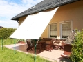 Vela ombreggiante impermeabile bianca 2,5x3 m tesa sopra una terrazza con mobili in legno presso una casa singola