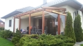 Vela ombreggiante retrattile Premium impermeabile in beige su una terrazza sotto un pergolato in legno