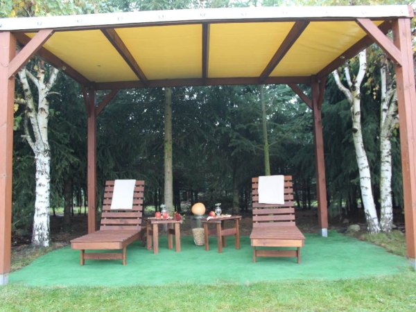 Toit de terrasse en PVC sur mesure installé sur une pergola en bois avec transats et tables dans un jardin