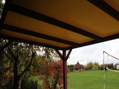 Toit de terrasse en PVC sur mesure et toutes saisons, monté sur une structure en bois dans le jardin.