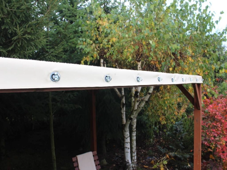 Toit de terrasse en PVC sur mesure toutes saisons avec œillets de montage résistants sur fond d'arbres d'automne