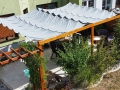 Vela ombreggiante grigia impermeabile Premium 2,5x3 m tesa sopra un pergolato in legno su una terrazza con mobili da relax