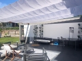 Vela ombreggiante bianca impermeabile estensibile 2,5x3 m su una terrazza moderna con mobili da giardino