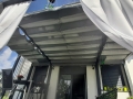 Rulou roman terasa Premium gri cu dimensiuni de 2,5x4 m montat sub acoperișul unei pergole moderne lângă casă