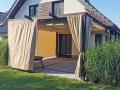 Rulou roman impermeabil pentru terasă Premium 2,5x4 m montat pe o pergolă de lemn lângă o casă modernă