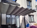 Rulou roman gri pentru terasă 2,5x4 m montat deasupra mobilierului de grădină pe terasa unei case luminoase