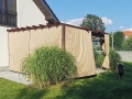 Rulou roman de terasă Premium bej care protejează de soare și ploaie, montat pe o pergolă de lemn în grădină