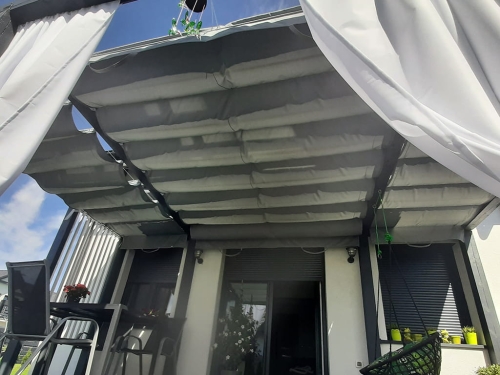 Store romain de terrasse gris 3x3 m Premium installé sur une pergola moderne près de la maison avec des rideaux blancs
