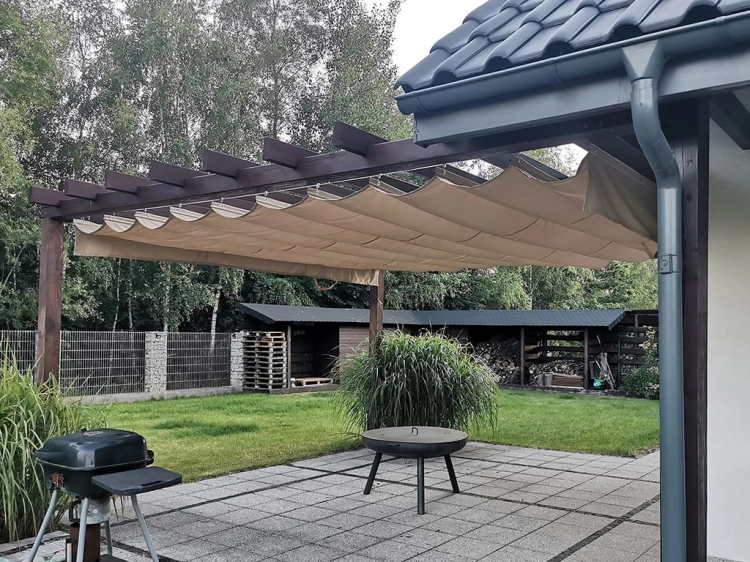 Store bateau de terrasse beige 3x4 m installé sous une pergola en bois sur une terrasse moderne
