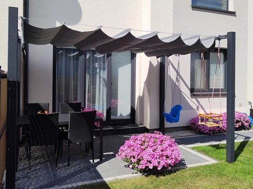 Store romain gris de terrasse 3x4 m au-dessus d'un salon de jardin et de balançoires sur une terrasse moderne