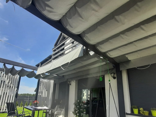 Store romain de terrasse imperméable Premium 4x4 m gris monté sur une pergola moderne près de la maison