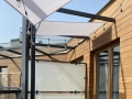 Toldo vela cuadrado impermeable de 4x4 m montado sobre terraza con moderna iluminación de guirnaldas