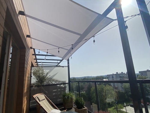 Voile d'ombrage blanche imperméable 3x4,5 m installée sur une terrasse au-dessus d'un transat et de plantes en pot
