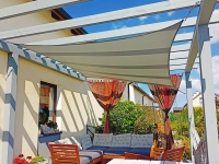 Voile d'ombrage rectangulaire imperméable 3x4,5 m premium installée sur une terrasse avec mobilier de jardin