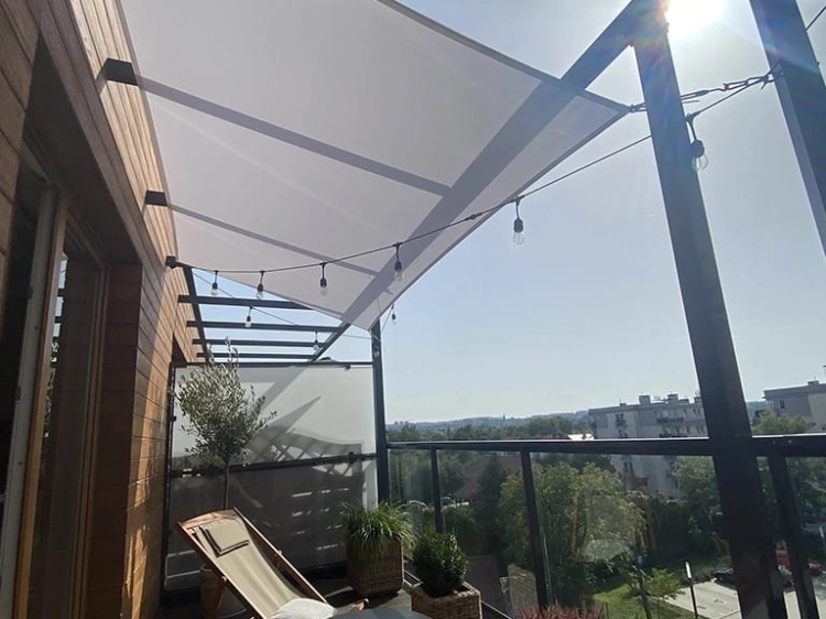 Vela de sombra impermeable blanca 3x4 m instalada sobre una terraza con muebles de jardín e iluminación ambiental