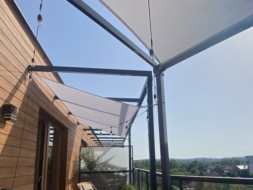 Toldo vela rectangular premium impermeable instalado en terraza sobre estructura negra e iluminación