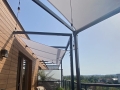 Wasserdichtes Sonnensegel 3x3 m auf einer Terrasse über einer Lichterkette montiert